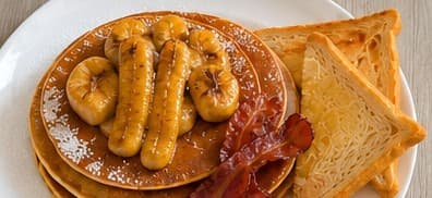 Hanover Big Fluffy Pancakes topped with caramelised banana, with bacon and toast